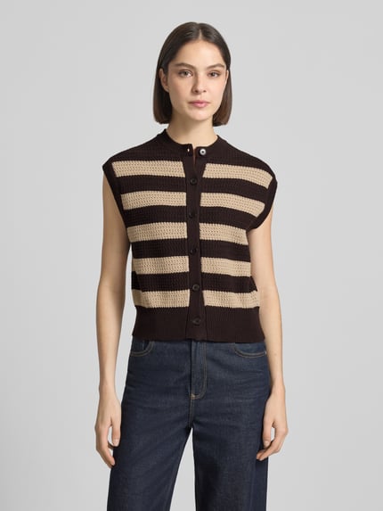 Frauenmodel trägt Regular Fit Weste in Strick-Optik Modell 'Lydisy' von Drykorn aus Reine Baumwolle mit Knopfleiste, elastische Abschlüsse, gestreiftes Muster in Beige und Dunkelbraun, Rückenlänge bei Größe S: 50 cm, Ganzkörperansicht von vorne.
