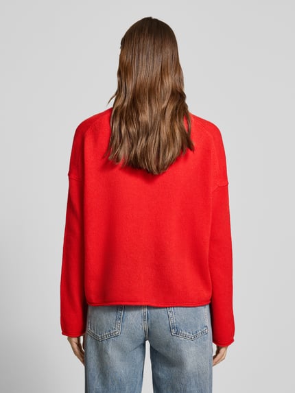 Frauenmodel trägt Oversized Strickjacke aus reiner Schurwolle von Marc O'Polo in Unifarbe Rot, Strick-Textur, Ganzkörperansicht Rückansicht.