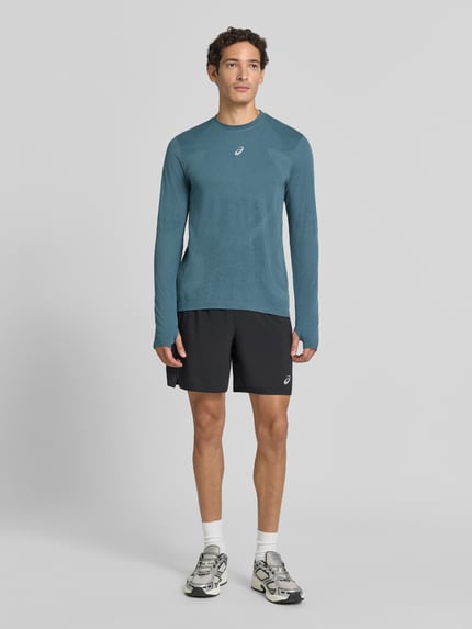 Männermodel trägt Longsleeve mit Logo-Print und Rundhalsausschnitt von ASICS, Blau, glatte Textur, gerader Schnitt, Ganzkörperansicht von vorne. Modell ROAD SEAMLESS, Rückenlänge Größe M: 70 cm.
