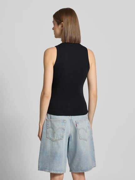 Frauenmodel trägt Tanktop in Ripp-Optik Modell 'Philips' von Carhartt Work In Progress, schwarzer Baumwoll-Elasthan-Mix, Slim-Fit, Rundhalsausschnitt, Rückenlänge bei Größe S: 53 cm, Ganzkörperansicht Rückansicht.