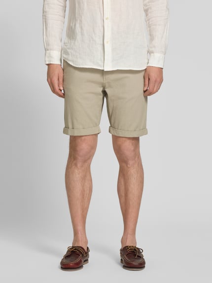 Mężczyzna nosi Slim Fit Chinoshorts aus Baumwoll-Mix Modell 'LUTON' von SELECTED HOMME, beżowe, drobna struktura, widok z przodu, ujęcie całej sylwetki.