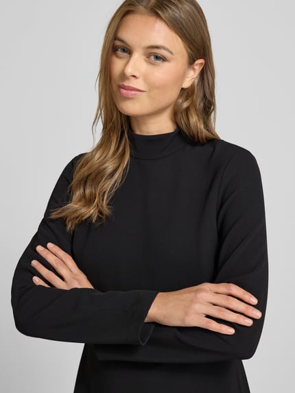 Frauenmodel trägt Minikleid mit Stehkragen von Calvin Klein Womenswear, schwarzer Elastischer-Material-Mix, taillierte Passform, Nahaufnahme Oberkörper.
