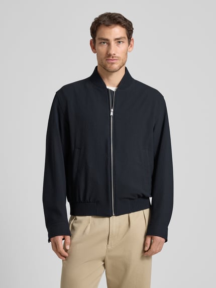 Männermodel trägt Regular Fit Blouson mit Baseball-Kragen Modell 'H-COMBO' von BOSS, Optik:Allover-Muster, Seersucker, Ganzkörperansicht von vorne.