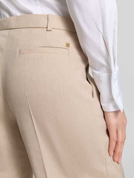 Frauenmodel trägt Weite Hose aus Viskose-Mix Modell 'HALATI' von HUGO in Bi-Color Optik mit Logo-Applikation, Nahaufnahme Rückansicht.