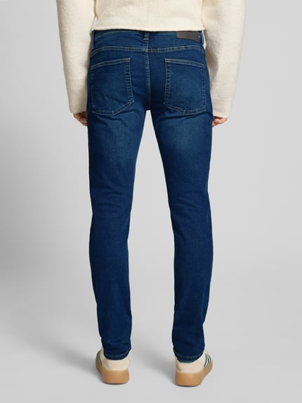Męski model nosi Slim Fit Jeans aus Baumwoll-Mix Modell 'LOOM' von Only & Sons, kolor jednolity, denim, krój slim fit, widok całej sylwetki od tyłu.