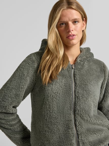 Frauenmodel trägt Regular Fit Teddyjacke mit Kapuze Modell 'NEWANNA' von ONLY, Damen Sweatjacke, grün, flauschige Textur, Nahaufnahme Oberkörper.