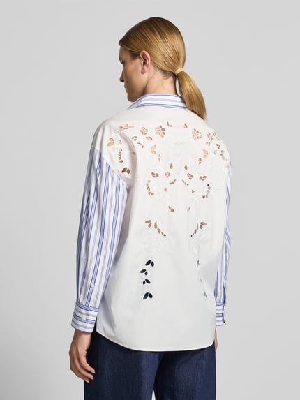 Vrouwenmodel draagt Loose Fit Hemdbluse aus reiner Baumwolle van Weekend Max Mara, effen optiek met all-over patroon, lange mouw, kraag en manchetten, doorknoopsluiting, broderie details op de rug, puur katoen, achteraanzicht, detailopname.
