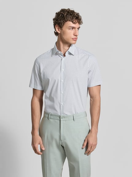 Męski model nosi Regular Fit Business-Hemd aus Baumwolle mit Kentkragen od Christian Berg Men, krój regular fit, biały w kratkę, czysta bawełna, allover-look, długość pleców w rozmiarze 39/40: 77 cm, szerokość w rozmiarze 39/40: 44 cm, długość rękawa w rozmiarze 39/40: 23 cm, zdjęcie całej sylwetki z przodu.