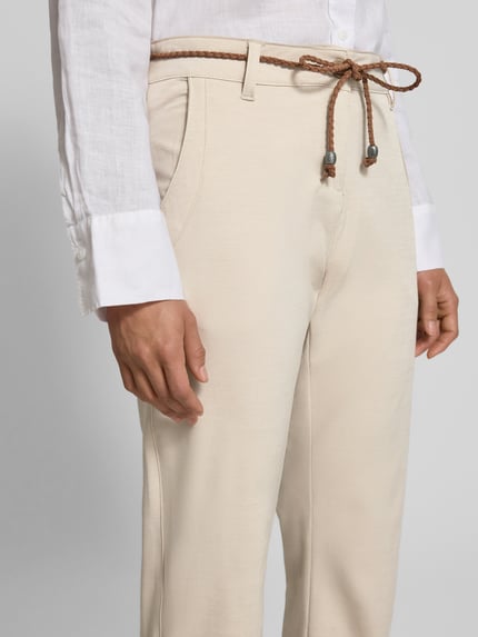 Frauenmodel trägt Stoffhose mit Bindegürtel und Eingrifftaschen von G.I.G.A. DX in Beige, Baumwoll-Mix, Nahaufnahme Oberkörper.