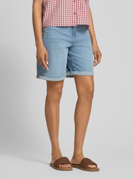 Vrouwenmodel draagt Regular Fit Jeansshorts uit katoenmix model 'SURI' van s.Oliver RED LABEL, denimlook lichtblauw, 5-pocket-design, knoop- en ritssluiting, met riemlussen, studs, label patch, omgeslagen zoom; vooraanzicht volledige lichaamsopname.