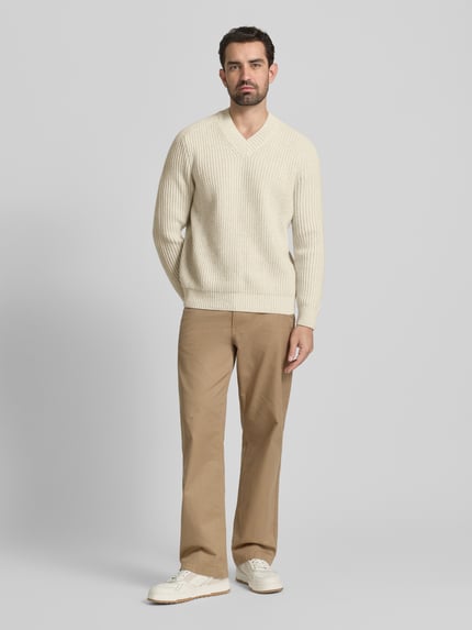 Männermodel trägt Shaped Fit Strickpullover aus Schurwoll-Mix Modell 'KARINET' von BOSS Orange, Optik: Unifarben, Zopfmuster, Ganzkörperansicht von vorne.
