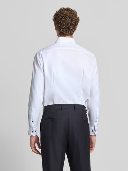 Männermodel trägt Modern Fit Businesshemd aus reiner Baumwolle von OLYMP, weiß, glatte Textur, schwarze Hose, Ganzkörperansicht Rückansicht, Herren Businesshemd von OLYMP.