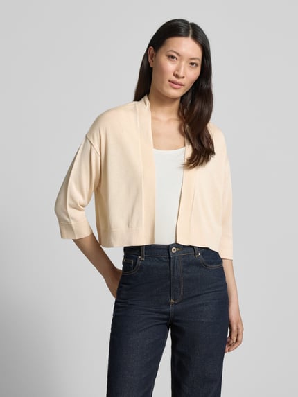 Vrouwenmodel draagt Strickjacke aus Lyocell-Baumwoll-Mix in offener Passform van comma, regular fit, 3/4-mouw, lichte beige kleur, gladde textuur, voorkant borsthoogte.