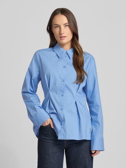 Frauenmodel trägt Hemdbluse aus Baumwoll-Mix Modell 'Zopy' von Gestuz in Hellblau, taillierte Passform, Sportmanschetten, Knopfleiste, Langärmelig, Ganzkörperansicht von vorne. Kontext: Damen Hemdbluse, elastischer Baumwoll-Mix, Hemdblusenkragen, Rückenlänge bei Größe 36: 68 cm, Ärmellänge: 63 cm.