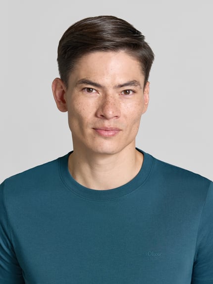 Männermodel trägt Regular Fit T-Shirt aus reiner Baumwolle von s.Oliver RED LABEL in Uni-Optik, Rundhals, Jersey, Nahaufnahme Oberkörper.