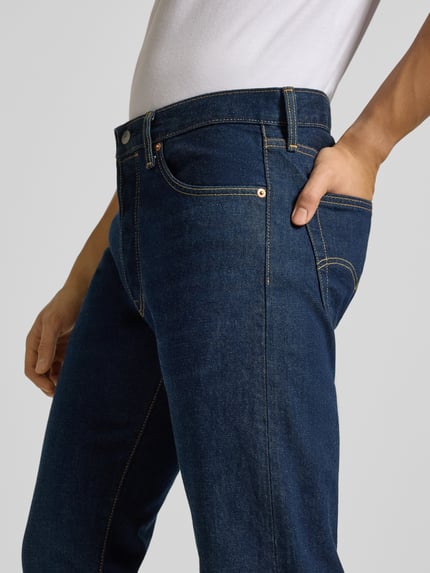 Mężczyzna nosi Wide Fit Jeans mit 5-Pocket-Design od Levi's®, ciemnoniebieski denim, bawełna z elastanem, zbliżenie na górną część ciała.