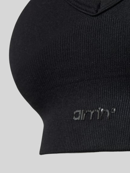 Produktfoto, czarny Bustier mit Stretch-Anteil von aim'n, elastyczny materiał, przylegający krój, szeroki ściągacz, detal z logo, tekstura prążkowana