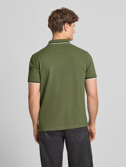 Männermodel trägt Slim Fit Poloshirt mit Label-Stitching von CHAMPION aus Reine Baumwolle in Grün, Produktdetails auf Rückansicht
