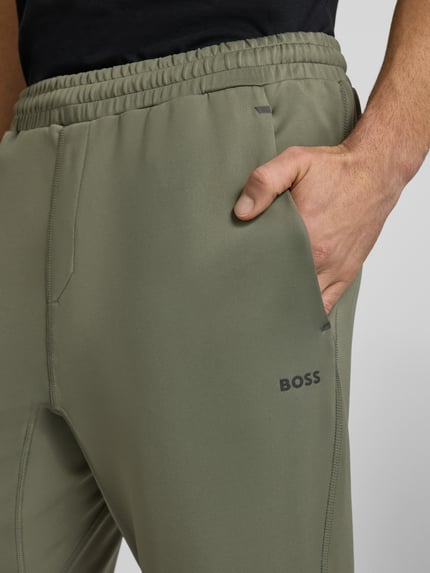 Männermodel trägt Regular Fit Sweatpants aus schnell trocknenden Material Modell 'HICON ACTIVE' von BOSS Green, Optik: Unifarben, Label Print, Bundabschluss: elastisch, Flatlock-Innennähte, seitliche Eingrifftaschen, Gesäßtasche, Nahaufnahme Oberschenkel.
