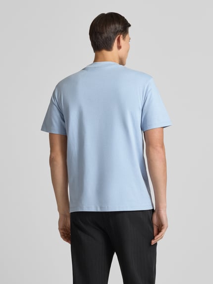 Männermodel trägt Relaxed Fit T-Shirt aus reiner Baumwolle Modell 'DAPOLINO' von HUGO in Hellblau, unifarben, Ganzkörperansicht Rückansicht.