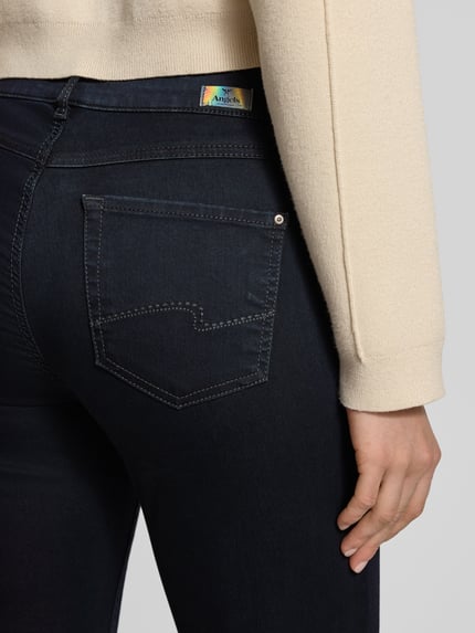 Frauenmodel trägt Bootcut Jeans mit Kontrastnähten Modell 'CICI' von Angels aus Baumwoll-Elasthan-Mix, 5-Pocket-Design, Detailaufnahme Rückansicht.