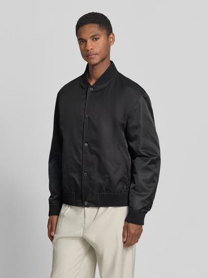 Männermodel draagt Relaxed Fit blouson model 'H-COVER' van BOSS, look: effen, pasvorm: relaxed fit, logo-applicatie, knoopsluiting, steekzakken, binnenzak, mouwboord en rompzoom geribd, Ganzkörperansicht van voren.