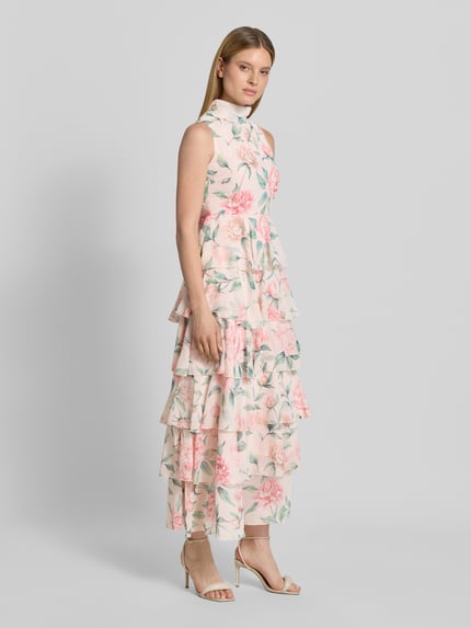 Modelka kobieca ma na sobie tailliertes Freizeitkleid mit Volants Modell 'FELICIA' od Vero Moda, wielokolorowy kwiatowy wzór, chiffon, midi, widok całej sylwetki z przodu.