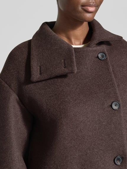 Frauenmodel trägt Loose Fit Kurzmantel aus Wolle Modell 'MAJELAA WOOL' von ARMEDANGELS, braune Filzoptik, Nahaufnahme Oberkörper.