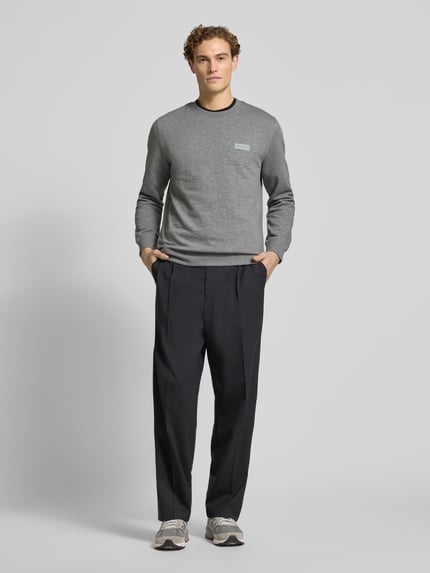 Männermodel trägt Regular Fit Sweatshirt aus reiner Baumwolle von Marc O'Polo in Optik: Unifarben mit Label-Patch, Langarm, Rundhals, Sweat-Material, Ganzkörperansicht von vorne.
