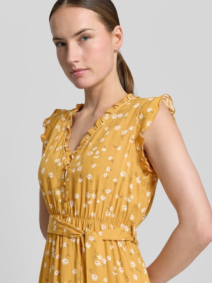 Vrouwenmodel draagt Minikleid aus Viskose mit Bindegürtel und Kappärmeln van Apricot, zuiver viscose, getailleerd model, V-hals met ruches, knoopsluiting, kapmouwen, strikceintuur, laagjeslook, ruglengte maat S: 89 cm, borstwijdte maat S: 38 cm, warme mosterdgele tint met witte bloemenprint, zachte en gladde textuur. Nahaufnahme bovenlichaam.