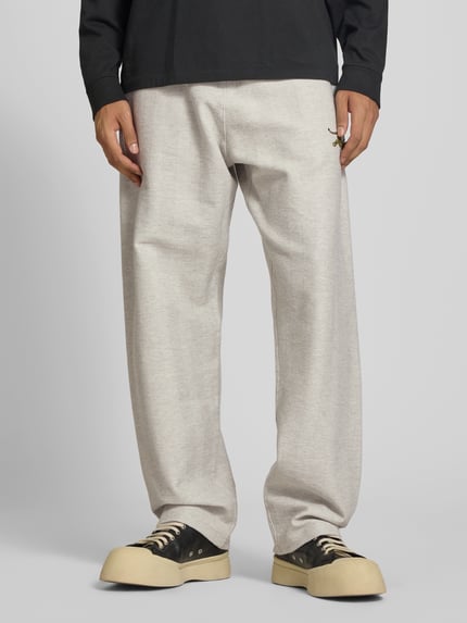 Männermodel trägt Sweatpants aus Baumwoll-Mix von Kenzo in Hellgrau mit Label-Print, lockerer Passform und elastischem Bund, Ganzkörperansicht von vorne.