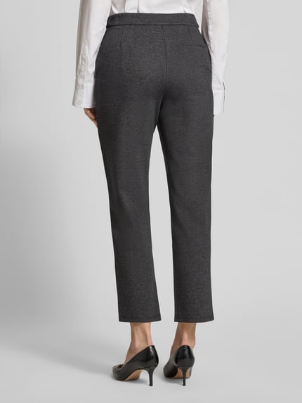 Frauenmodel trägt Hose aus Viskose-Mix Modell 'CHARLIE' von GUIDO MARIA KRETSCHMER WOMAN, dunkler Farbton, Regular-Fit, Paspeltasche, Ganzkörperansicht Rückansicht. Bundweite 39 cm, Innenbeinlänge 68 cm bei Größe 36, leichte Struktur.