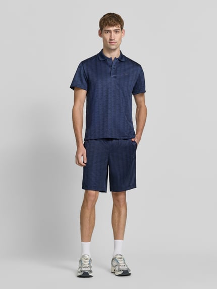 Männermodel trägt Regular Fit Sweatshorts mit Tunnelzug von Lacoste in Dunkelblau mit glatter Textur, Ganzkörperansicht von vorne. Herren Sweatshorts von Lacoste