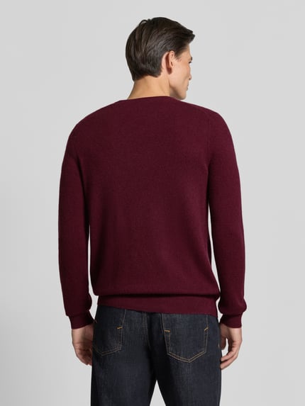 Mannenmodel draagt gebreide pullover van kasjmier met v-hals van Christian Berg Men in bordeaux, regular fit, ruglengte maat M 71 cm, mouwlengte maat M 71 cm, ganzichtsopname rugaanzicht.