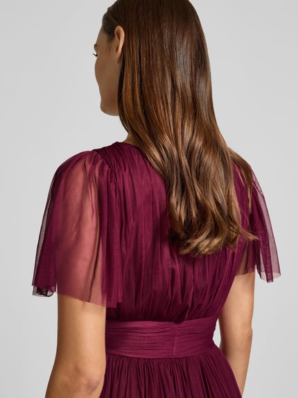 Modelka kobieca nosi 'Abendkleid mit tiefem V-Ausschnitt' od LACE & BEADS w kolorze burgundowym, efekt stopniowania, tasiemka w talii, długość tyłu w rozmiarze S: 149 cm, szerokość w rozmiarze S: 38 cm, długość rękawów w rozmiarze S: 27 cm, tkanina półtransparentna, ujęcie z tyłu zbliżenie na górną część.