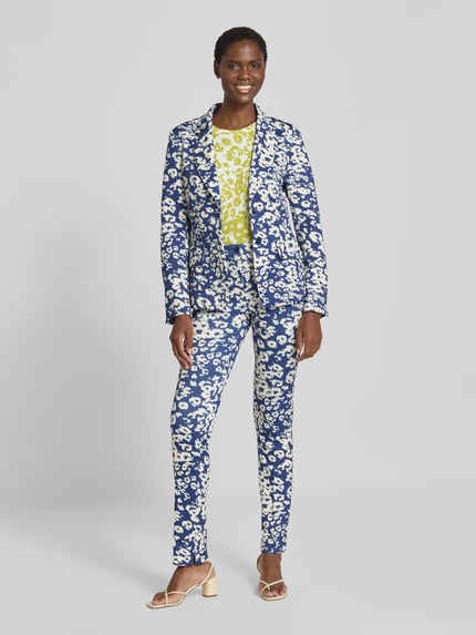 Modelka prezentuje Slim Fit Blazer mit Pattentaschen od Marc Cain, Mieszanka materiałów z dodatkiem streczu, wzór na całej powierzchni, Kołnierz z połami, kieszenie z patką, zapięcie na guzik, Długość tyłu w rozmiarze 36: 66 cm, Szerokość w rozmiarze 36: 47 cm, Długość rękawów w rozmiarze 36: 60 cm, jasnoniebieska i biała kolorystyka, tekstura tkaniny, Ganzkörperansicht z przodu.