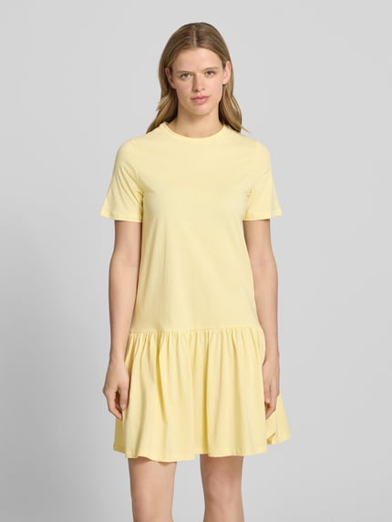Frauenmodel trägt Regular Fit T-Shirt-Kleid aus reiner Baumwolle Modell 'DISSO' von Pieces, Optik: Unifarben, Mini-Länge, Rundhals, Kurzarm, Volants, Ganzkörperansicht von vorne.