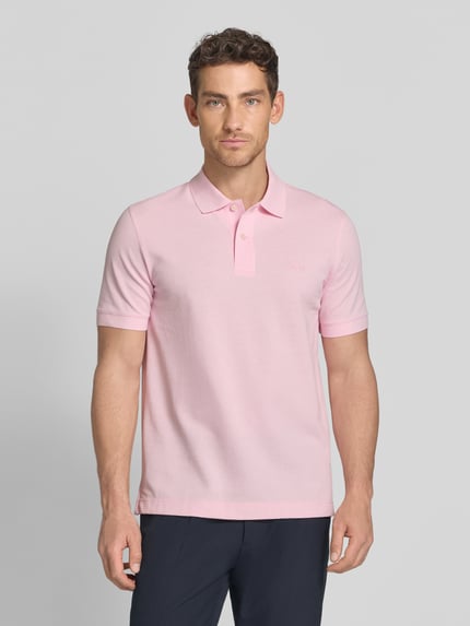 Męski model nosi Regular Fit Poloshirt aus reiner Baumwolle Modell 'PALLAS' von BOSS, efekt: jednolity kolor, wyhaftowane logo, kołnierzyk polo, dekolt w serek, krótka listwa guzikowa, krótki rękaw, zakończenia rękawów prążkowane, wykończenie z rozcięciami bocznymi, wykończenie materiału: pika, materiał: czysta bawełna, Ganzkörperansicht von vorne.