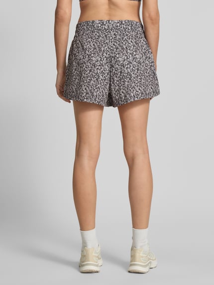 Frauenmodel trägt Running Shorts mit elastischem Bund Modell 'kallin' von VARLEY aus Material-Mix mit Stretch-Anteil, Relaxed-Fit, Ganzkörperansicht Rückansicht.