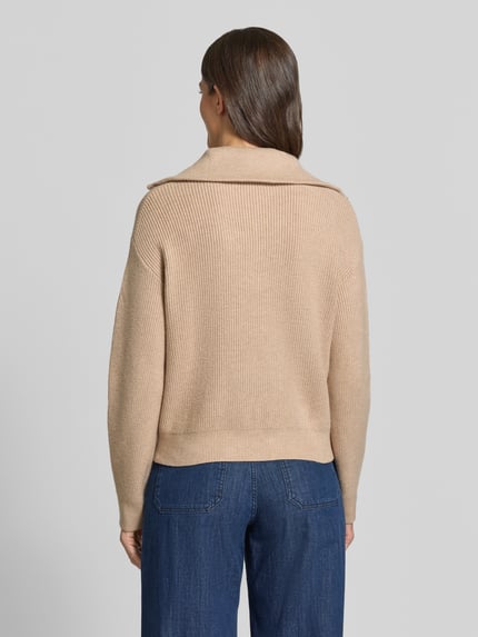 Frauenmodel trägt Troyer aus Viskose-Mix mit gerippten Abschlüssen Modell 'RIZON' von MANGO in Beige, lockere Passform, Ganzkörperansicht Rückansicht.
