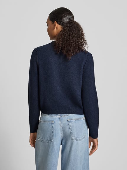 Frauenmodel trägt Strickjacke mit Rundhalsausschnitt und Knopfleiste von Oui in Dunkelblau, Material-Mix mit Woll-Anteil, Regular Fit, Jeans, Ganzkörperansicht Rückansicht.