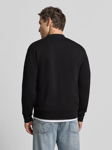 Männermodel trägt Slim Fit Pullover aus reiner katoen 'TOM' van Selected, zwart, eenvoudige vormen, gladde textuur, Ganzkörperansicht Rückansicht.