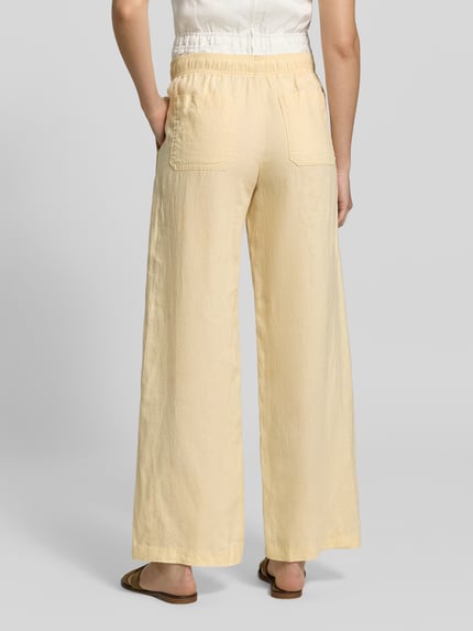 Frauenmodel trägt Leinenhose mit elastischem Bund Modell 'Mileni resort' von OPUS, Wide-Leg-Pants aus Reine Leinen, Gesäßtaschen, helles Beige, Struktur, Ganzkörperansicht Rückansicht.