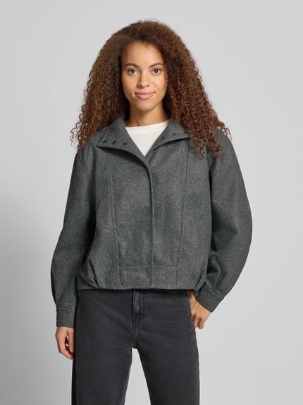Frauenmodel trägt Bomberjacke mit hohem Stehkragen von ONLY in Dunkelgrau, glatte Textur, Damen Bomberjacke, Ganzkörperansicht von vorne.
