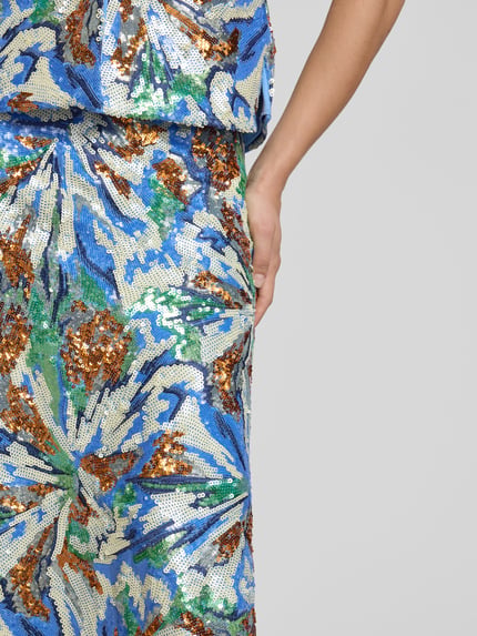 Frauenmodel trägt Midirock mit Allover-Pailettenbesatz von Rabanne, florales Design in Blau, Grün, Bronze, Detailaufnahme der Hüfte. Midirock zeichnet sich durch leichte A-Linie, Allover-Stitching, Nahtreißverschluss aus, Gesamtlänge 70 cm, Bundweite 40 cm.