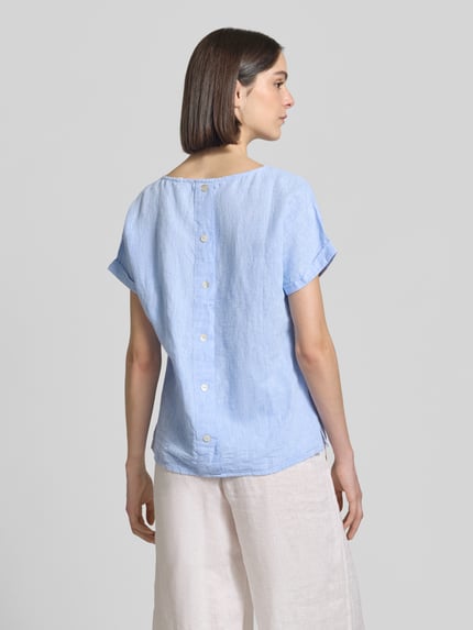 Frauenmodel trägt Leinenbluse mit fixiertem Ärmelaufschlag von Christian Berg Woman in Hellblau, aus Reines Leinen, Straight Fit, Rundhalsausschnitt, Rückenlänge bei Größe 36: 60 cm, Ärmellänge bei Größe 36: 10 cm, lockere Textur, Ganzkörperansicht Rückansicht.