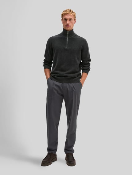 Männermodel trägt Pullover mit halblangem Reißverschluss von MARC O'POLO, unifarben, strukturierte Strickoptik, Ganzkörperansicht von vorne.