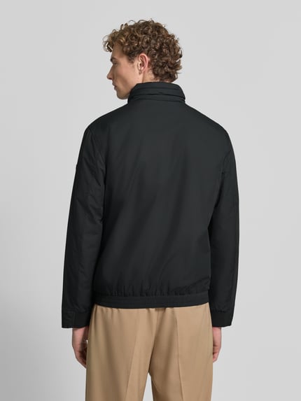 Męski model nosi czarną kurtkę pikowaną Regular Fit Steppjacke mit Stehkragen Modell 'LIGHT' von Strellson, Ganzkörperansicht Rückansicht, kurtka pikowana męska marki Strellson