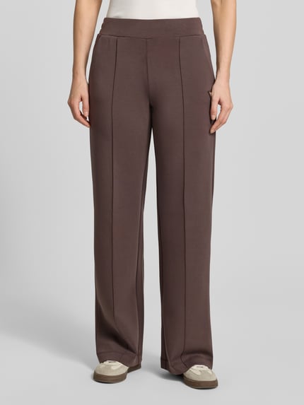 Vrouwenmodel draagt Straight Fit stoffen broek met modal-aandeel model 'Olympe' van Guess Activewear in elastische materiaalmix, binnenbeenlengte maat S 80 cm, ganzkörperansicht van voren.