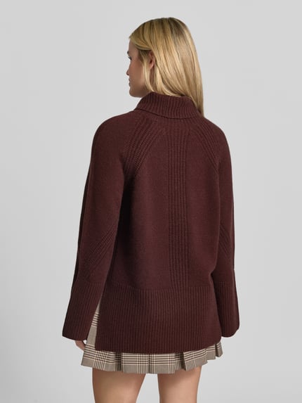 Frauenmodel trägt Oversized Pullover aus reinem Kaschmir von Joseph in Dunkelrot mit Strick-Optik, gerippten Abschlüssen, Rückansicht, KI-modifiziertes Bild